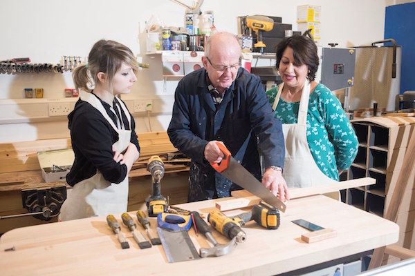 3 people cutting wood in the FabLab workshop